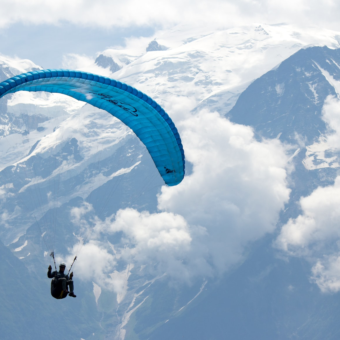 person in black and white parachute over snow covered mountain during daytime
